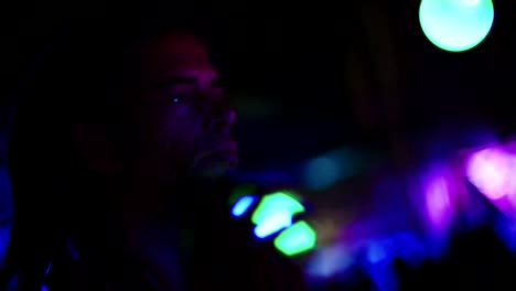 hombre haciendo malabarismos con bolas de luz durante una fiesta nocturna