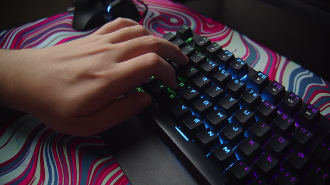primer plano de la mano presionando el teclado para juegos rgb con movimiento dinámico de la cámara