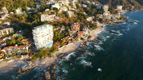 blue ocean waves crashing on the coastline beach of playa amapas in puerto vallarta mexico at sunset, aerial