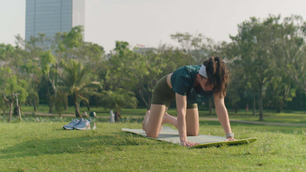 Woman Doing Vinyasa Yoga Outdoors in Park