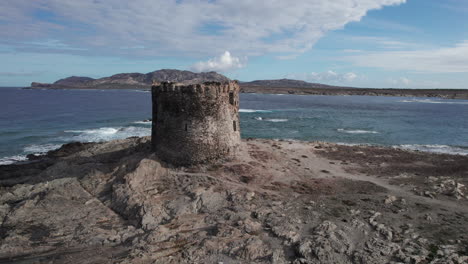 Isola-della-Pelosa,-Sardinia:-aerial-view-approaching-the-Torre-della-Pelosa-on-a-sunny-day