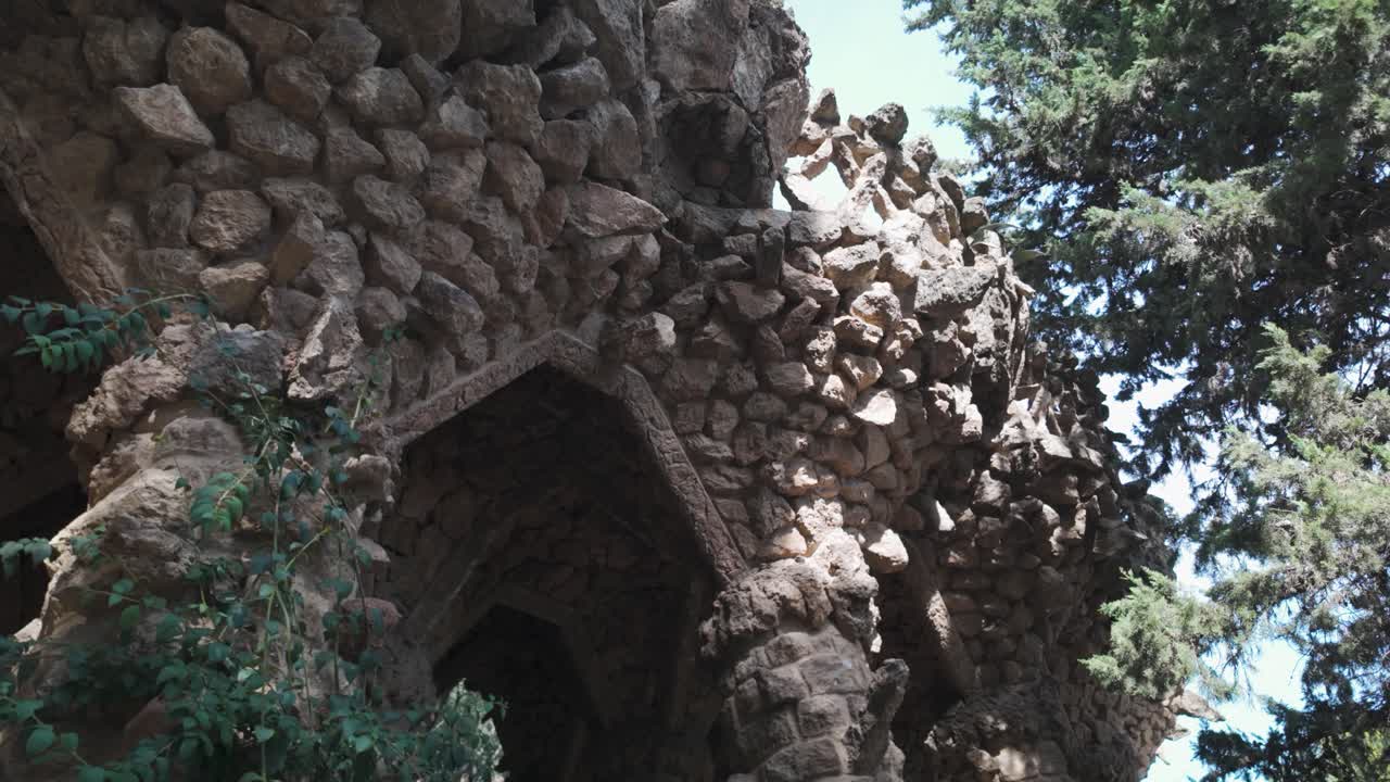 A detailed view of stone construction at Park Güell in Barcelona, merging nature and architecture.