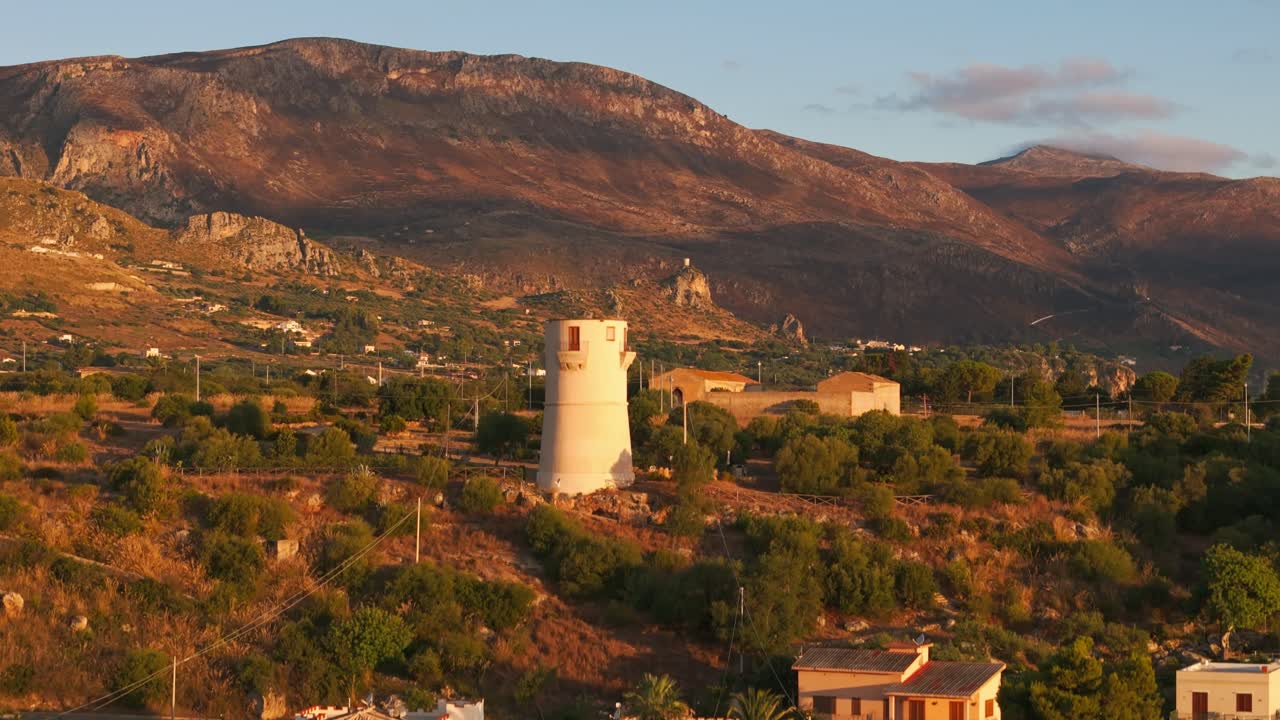 Rising aerial drone revealing Sicilian island, vast fields, and mountains, Sicily, Italy at sunrise with golden light and natural scenery