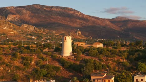 rising aerial drone revealing sicilian island, vast fields, and mountains, sicily, italy at sunrise with golden light and natural scenery