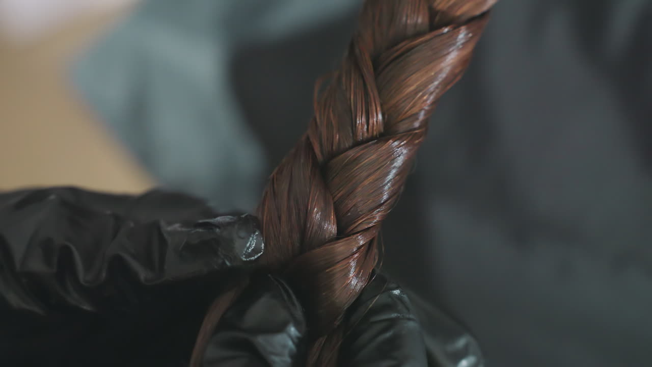 detailed view of polished braid, close examination of meticulously braided hair with shiny finish, an upclose perspective highlighting precise weaving and lustrous surface of braided hair