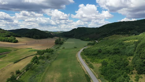 Aerial-view-of-car-driving-down-country-road-in-europe