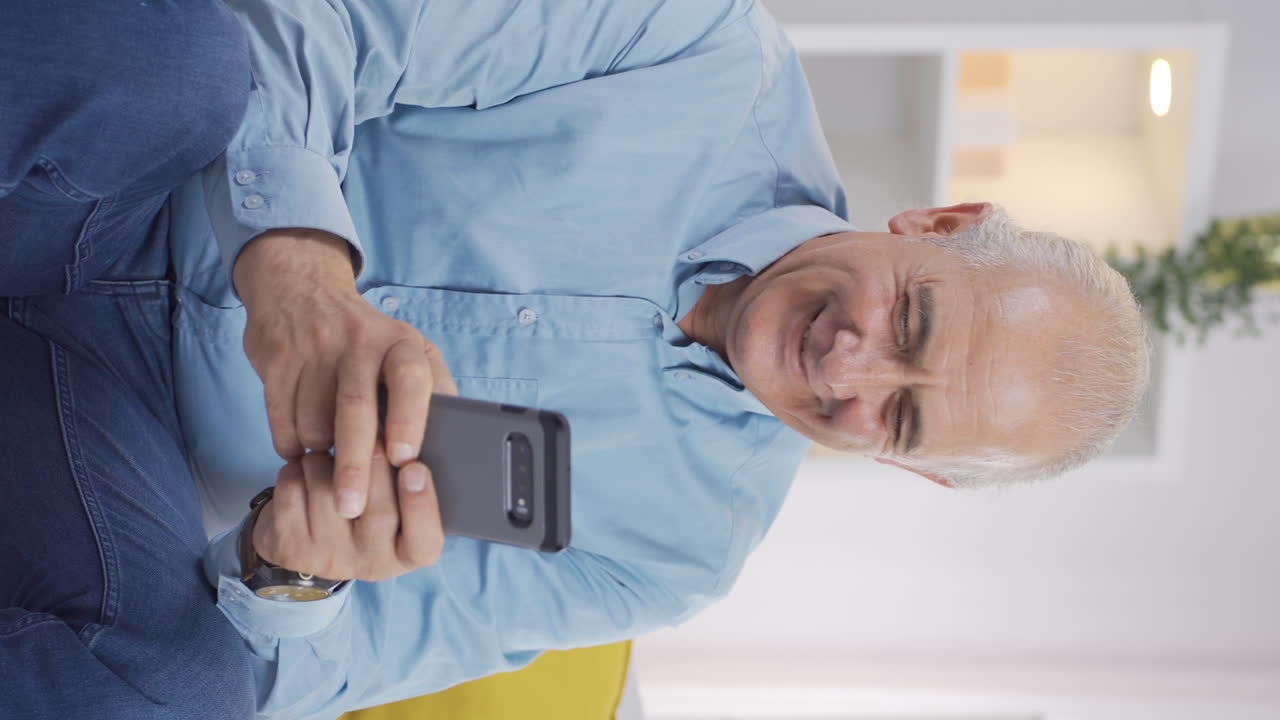 Video verticale di un uomo anziano felice e contento che messaggia