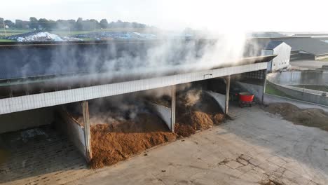 steam rising from composting manure at a farm storage facility