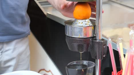 a man using a juicer to make orange juice