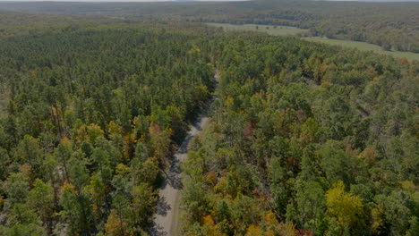 aerial following a country road in southern missouri countryside in autumn