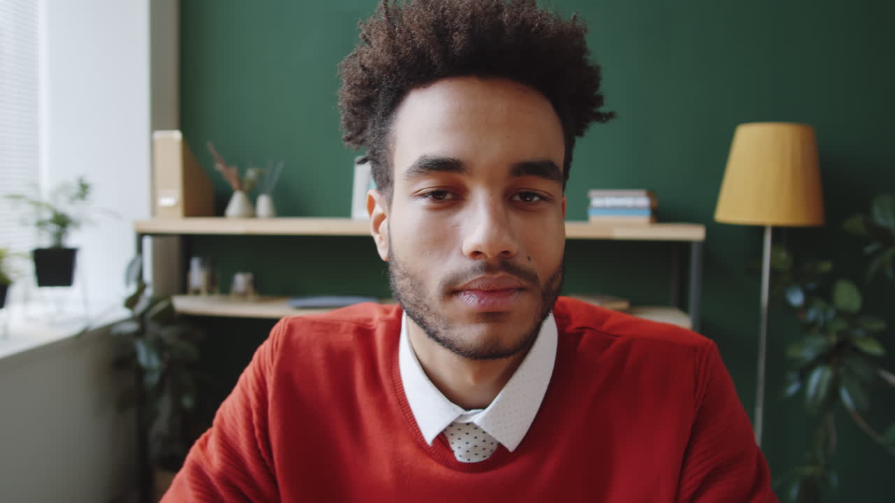 hombre con un suéter rojo durante una videoconferencia