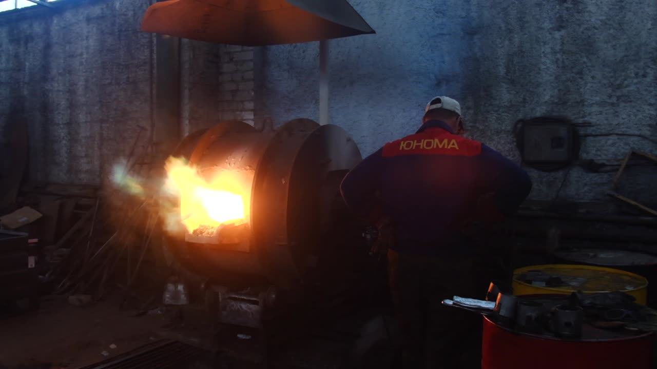 Metalworker observing a metal melting process in a workshop