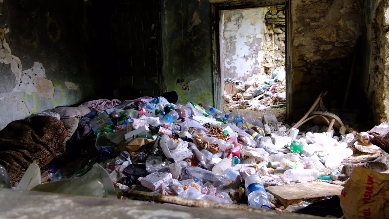A pile of plastic bottles and garbage in an abandoned buiding