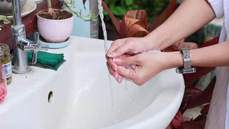 person washing hands at a sink