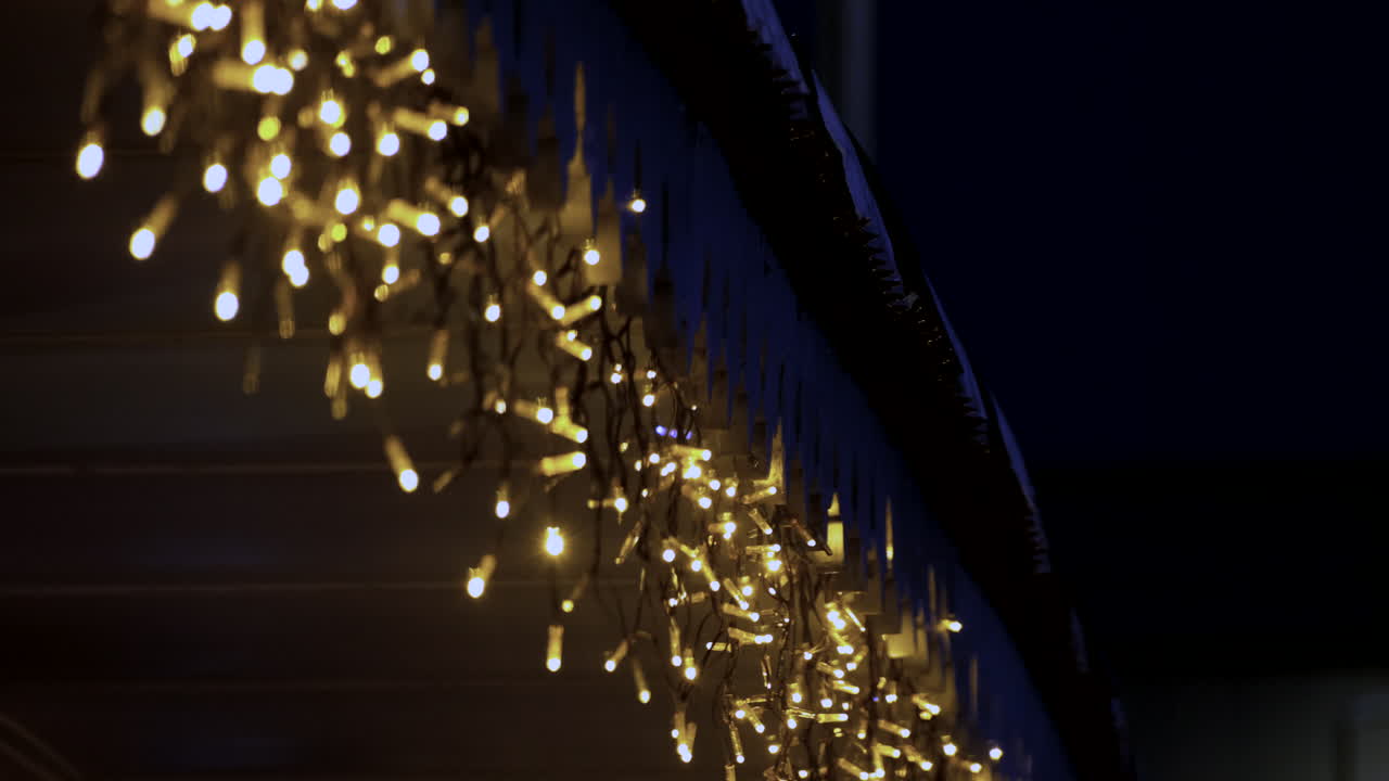 Flickering and illuminated string lights hanging at storefront in festive season