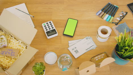 Fotografía-Cenital-De-Una-Máquina-De-Pago-Con-Tarjeta-Sin-Contacto-Y-Un-Teléfono-Móvil-Con-Pantalla-Verde-Sobre-La-Mesa