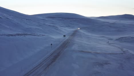 car driving on an icy road during strong winds in the most northern part of europe. aerial shot.