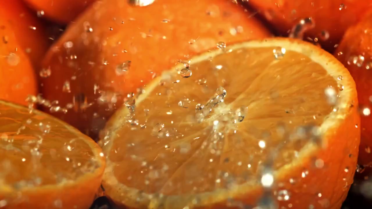Slow Motion Water Splashing on Fresh Juicy Orange Halves