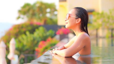 Sexy-Asian-Woman-in-Swimming-Pool-of-Luxury-Hotel-Resort-Enjoying-on-Hot-Sunny-Day