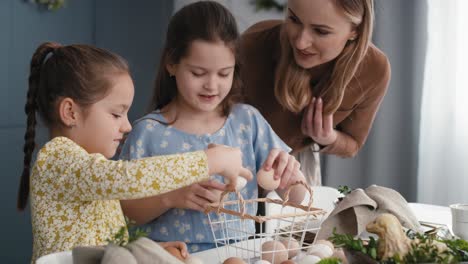 Kaukasische-Mutter-Und-Töchter-Während-Der-Osterzeit-Beim-Anordnen-Von-Eiern.