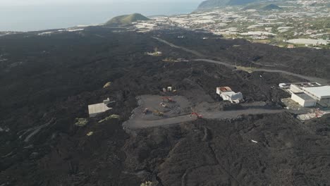 heavy diggers clear basalt amid the rugged aftermath of tajogaite volcano