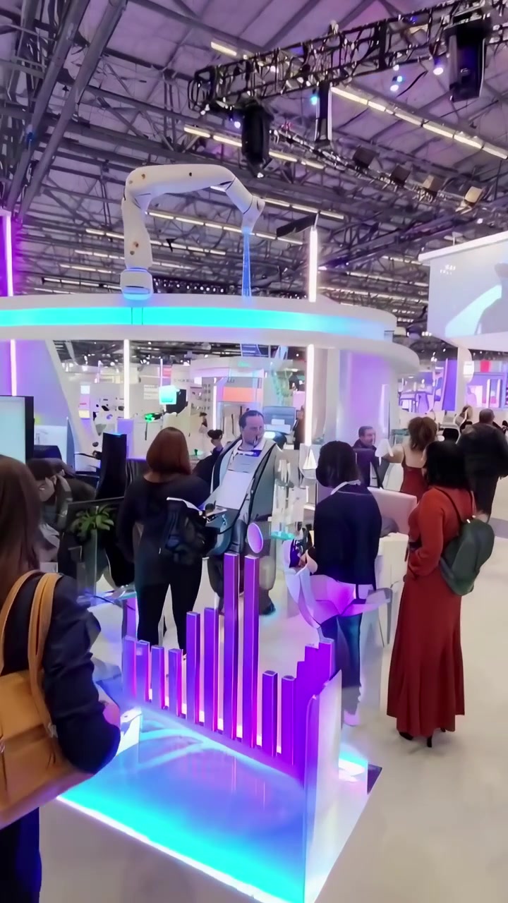 Visitatori esplorano una mostra di tecnologia moderna con un braccio robotico in mostra