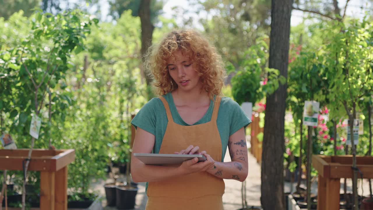 Frau arbeitet mit einem Tablet in einem Gartencenter