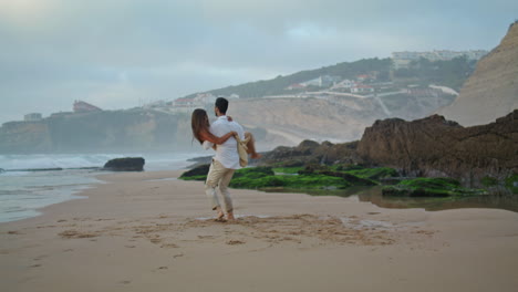 Amor-Pareja-Divirtiéndose-En-Vacaciones-Marinas.-Hombre-Gentil-Que-Lleva-A-Su-Esposa-En-La-Playa-Del-Mar