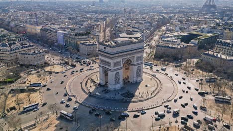 triumphal arch and car traffic on roundabout, paris cityscape, france