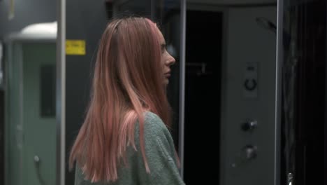 long haired woman in store chooses a shower stall for the bathroom