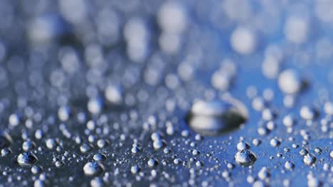 Micro-video-of-close-up-of-water-drops-with-copy-space-on-blue-background