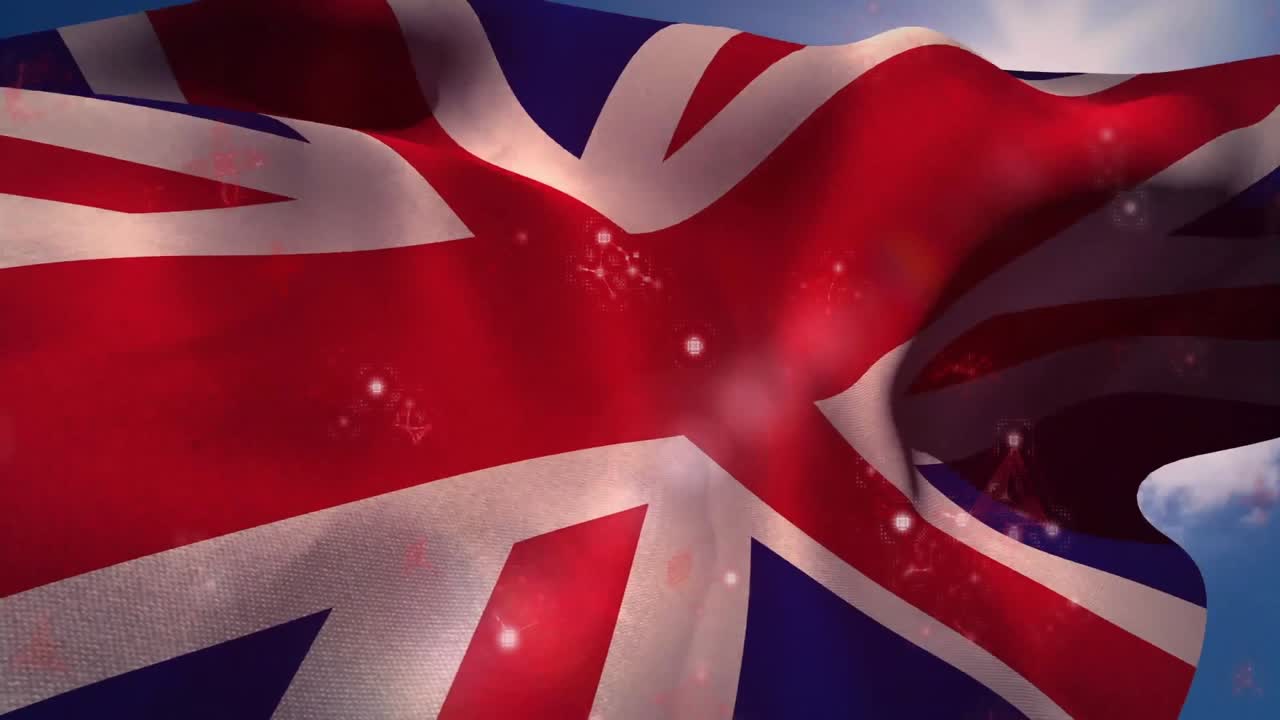 Brezza che si intensifica, bandiera Union Jack che sventola sotto il sole mentre particelle di luce fluttuano rivelando le pieghe.