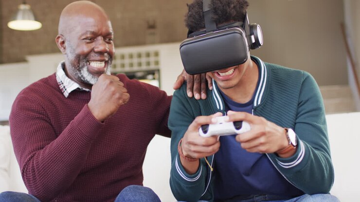 Happy african american son using vr headset and gamepad with senior father at home, slow motion