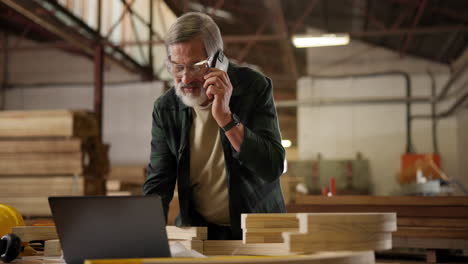 woodworker on a phone call in a workshop
