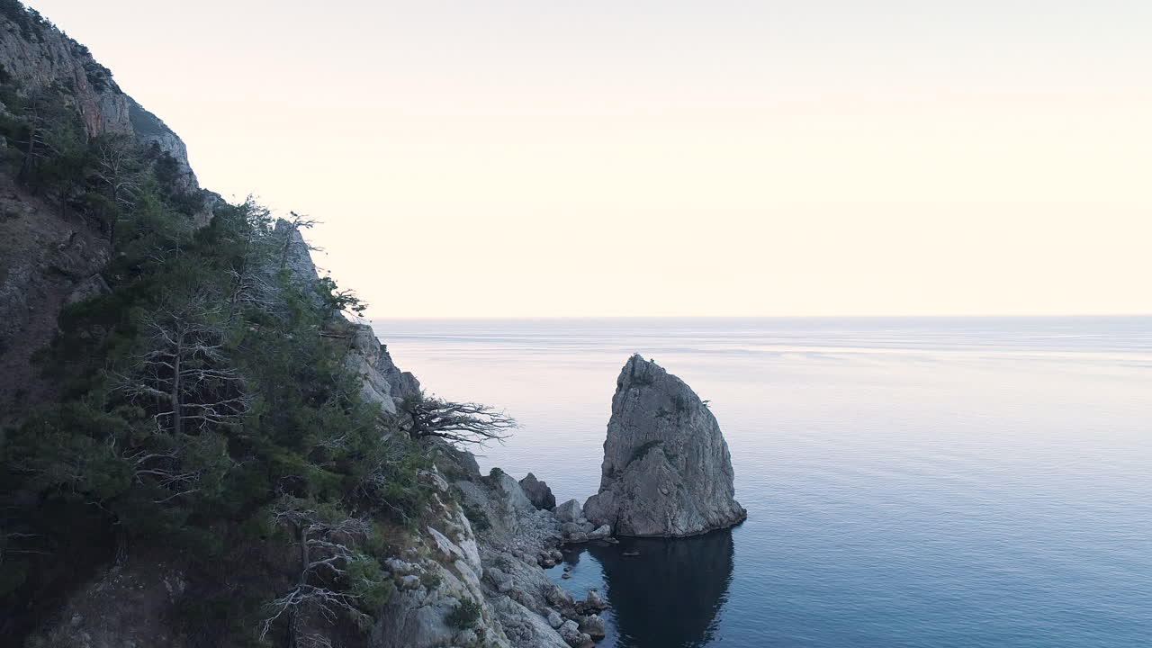 krajobraz przybrzeżny z dramatycznymi formacjami skalnymi i spokojnym morzem