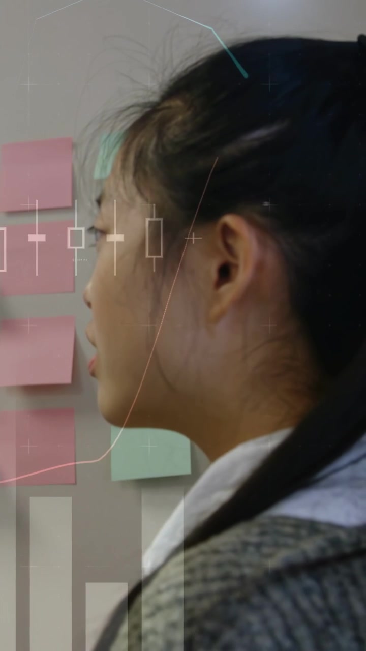 Woman turning toward sticky notes, scanning grid and planning business plan while charts overlaying