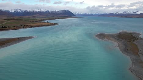 stunning turquoise blue waters of lake tekapo with mountain views in south island, new zealand. - aerial shot