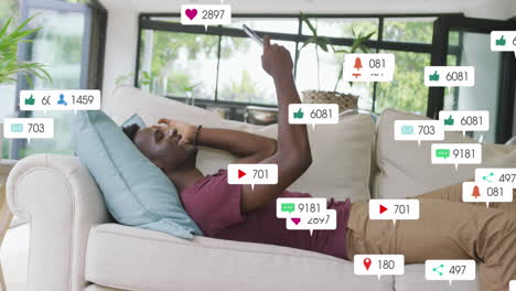 animation of notification bars over african american man lying on sofa and scrolling on cellphone