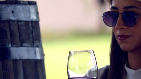 fashionable high class woman toasting red wine glass then drinking in slow motion