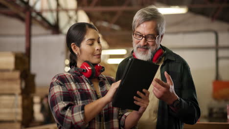 two woodworkers discussing plans on a tablet