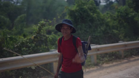man herding cattle on a country road