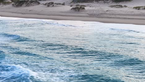 aerial view of waves crashing on a sandy beach
