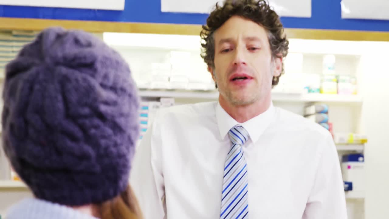 의약품 상자를 고객에게 주는 약사