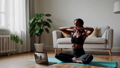 woman practicing yoga at home with an online class