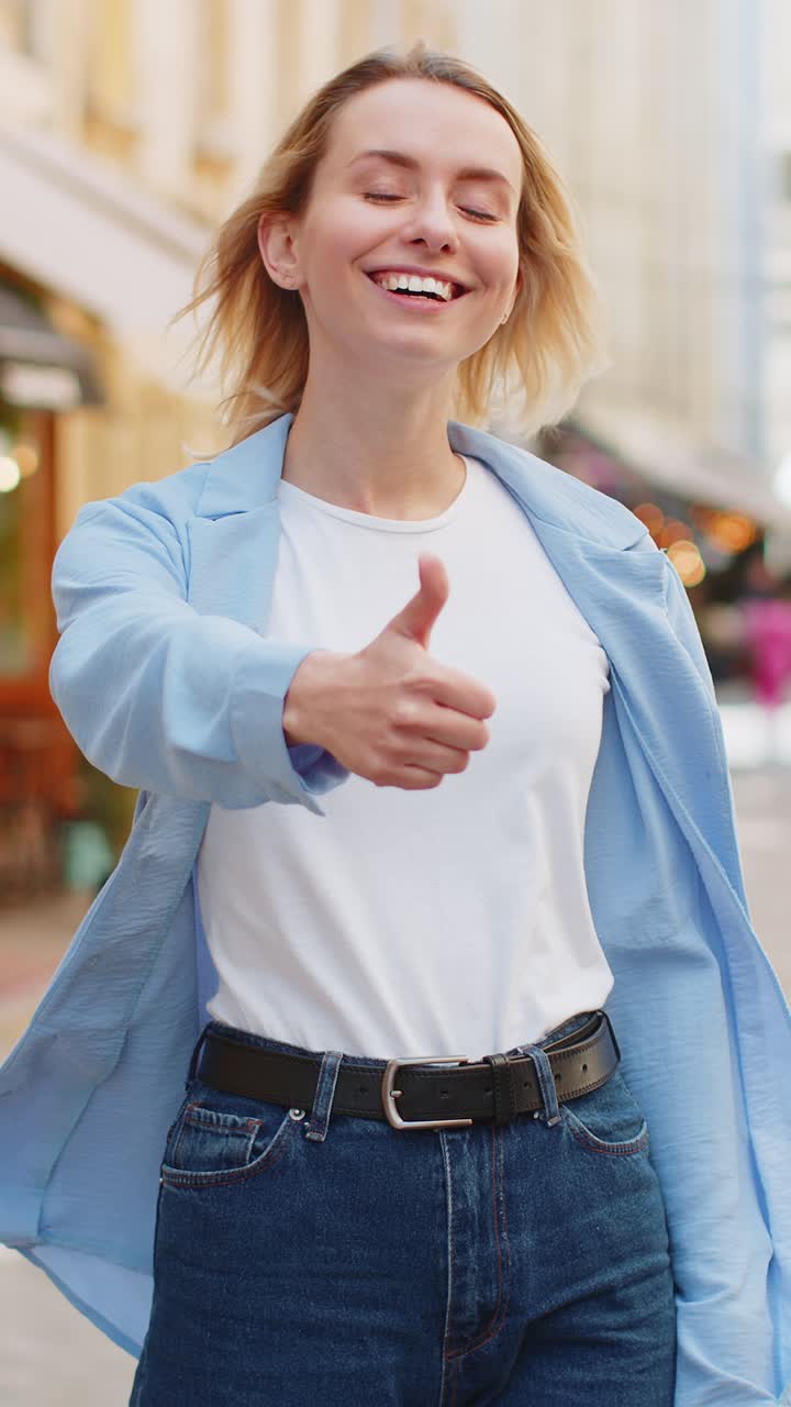 mujer turista feliz mostrando pulgares hacia arriba como algo positivo buena retroalimentación positiva en la calle de la ciudad