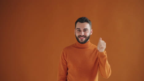 man in orange sweater with a smiling expression