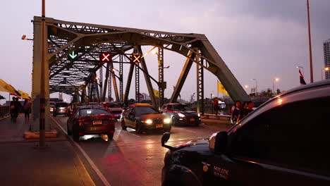 vehicles and motorcycles crossing the bridge at dusk