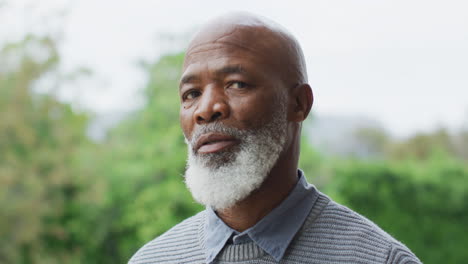 a senior african american man looking directly at camera outdoors