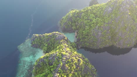 View-from-above,-stunning-aerial-view-of-a-turquoise,-crystal-clear-water-during-a-beautiful-sunrise