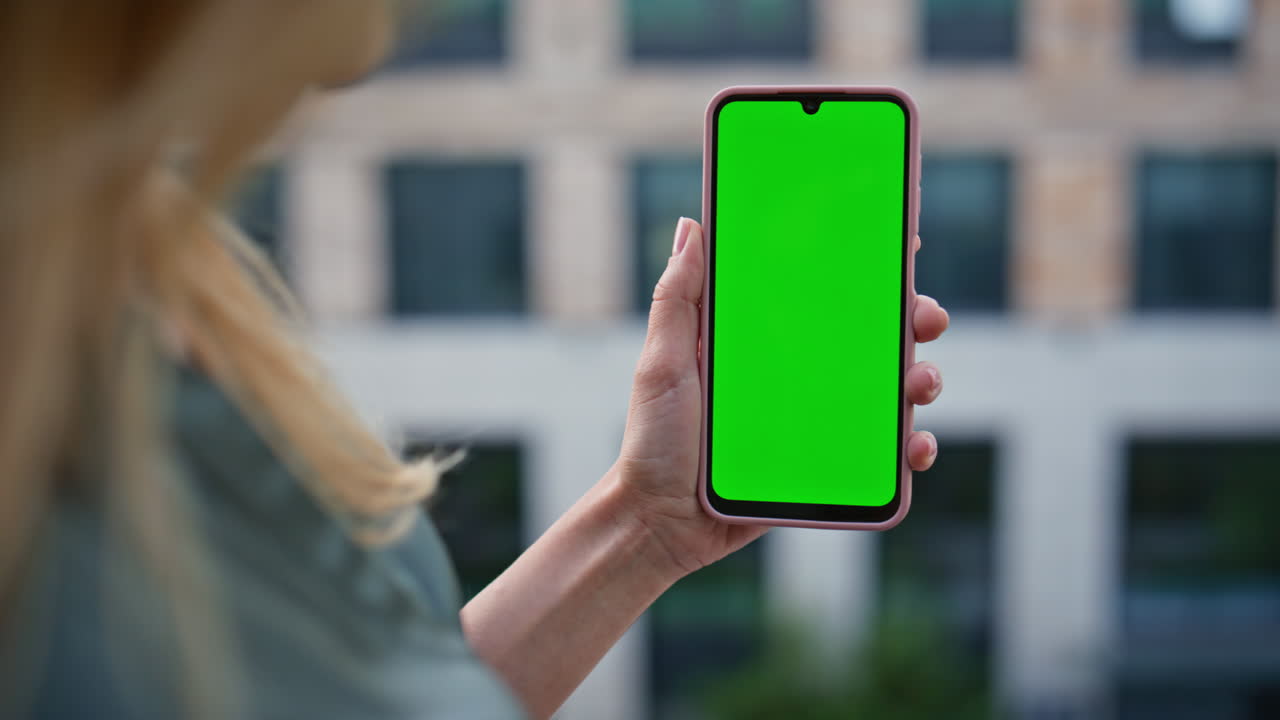 Lady hand tapping chroma smartphone near office building closeup. Woman online